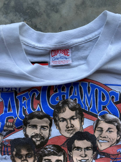 Close-up of a white vintage ACF Champions graphic t-shirt by CourtSide Customarily, featuring illustrated portraits of football players and blue lettering.